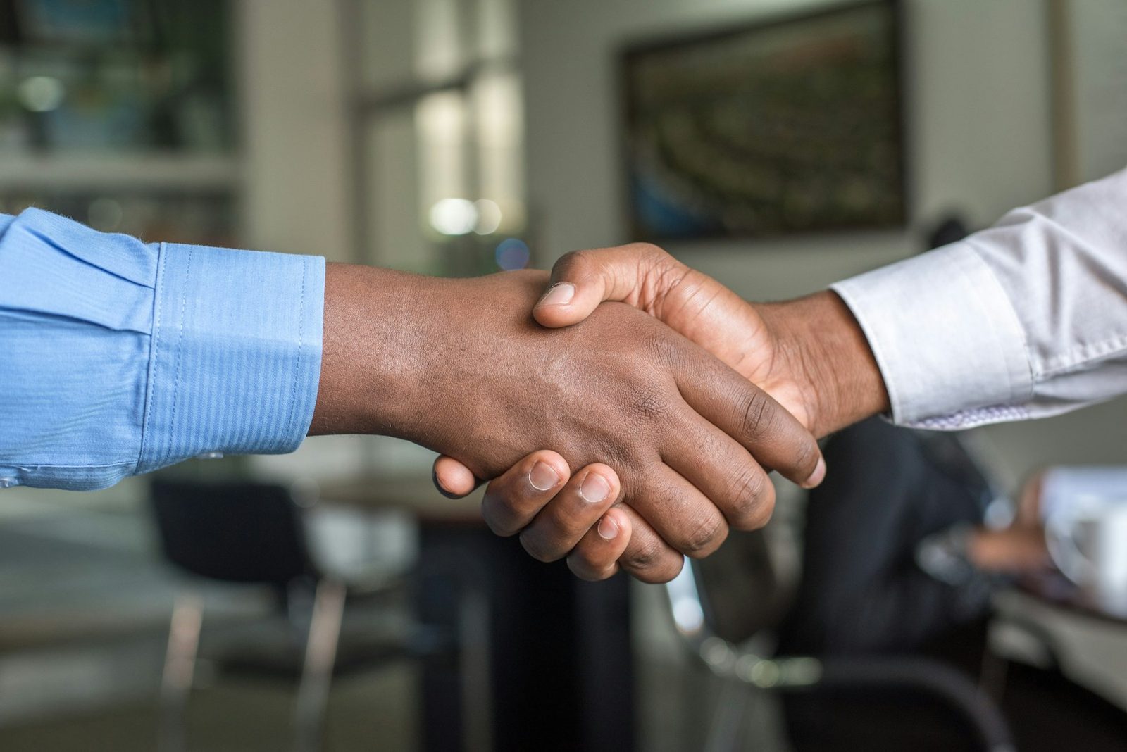 Two professionals shaking hands to mark a new partnership